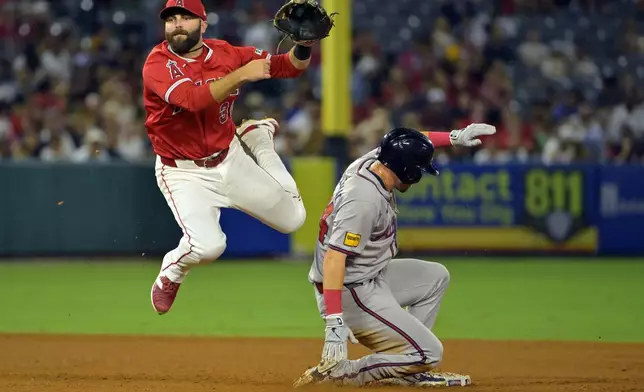 Atlanta Braves' Jarred Kelenic, right, is out at second as Los Angeles Angels' Michael Stefanic, left, throws to first to complete a double play in the sixth inning of a baseball game Friday, Aug. 16, 2024, in Anaheim, Calif. (AP Photo/Jayne Kamin-Oncea)