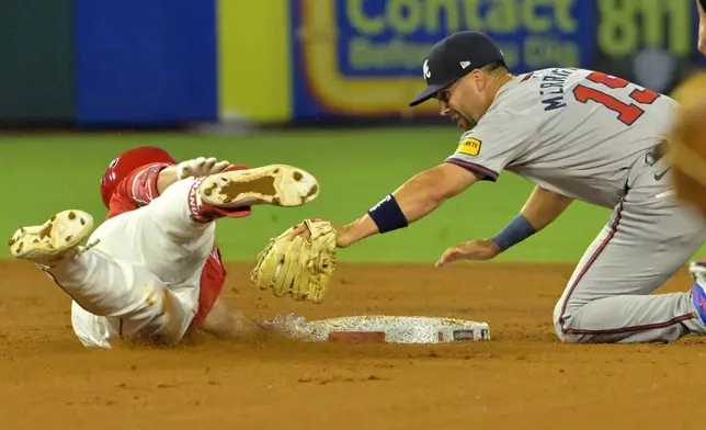 Los Angeles Angels' Nolan Schanuel, left, avoids a tag by Atlanta Braves' Whit Merrifield (15) for a double in the fourth inning of a baseball game Friday, Aug. 16, 2024, in Anaheim, Calif. (AP Photo/Jayne Kamin-Oncea)