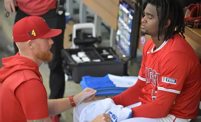 Los Angeles Angels' pitching coach Barry Enright, left, talks to starting pitcher Jose Soriano, right, in the dugout following the first inning of a baseball game against the Atlanta Braves, Friday, Aug. 16, 2024, in Anaheim, Calif. (AP Photo/Jayne Kamin-Oncea)