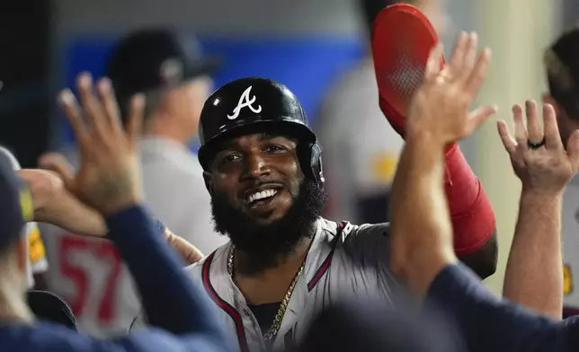 Atlanta Braves designated hitter Marcell Ozuna celebrates in the dugout after scoring off a two-run double hit by Travis d'Arnaud during the fifth inning of a baseball game against the Los Angeles Angels, Saturday, Aug. 17, 2024, in Anaheim, Calif. (AP Photo/Ryan Sun)