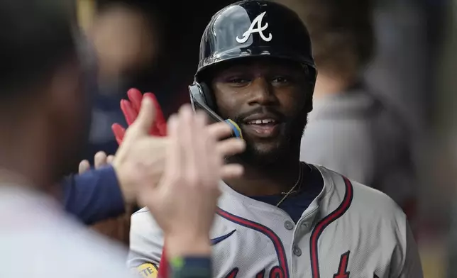 Atlanta Braves' Michael Harris II celebrates in the dugout after hitting a 2-run home run during the first inning of a baseball game against the Minnesota Twins, Tuesday, Aug. 27, 2024, in Minneapolis. (AP Photo/Abbie Parr)