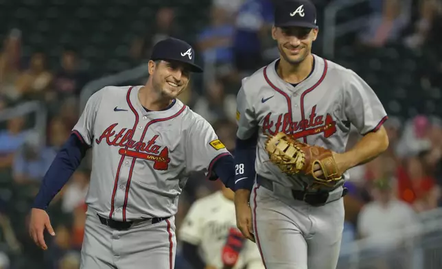 Atlanta Braves relief pitcher Luke Jackson, left, smiles appreciatively to first baseman Matt Olson after the latter made a diving catch to end the seventh inning of a baseball game against the Minnesota Twins, Wednesday, Aug. 28, 2024, in Minneapolis. (AP Photo/Bruce Kluckhohn)