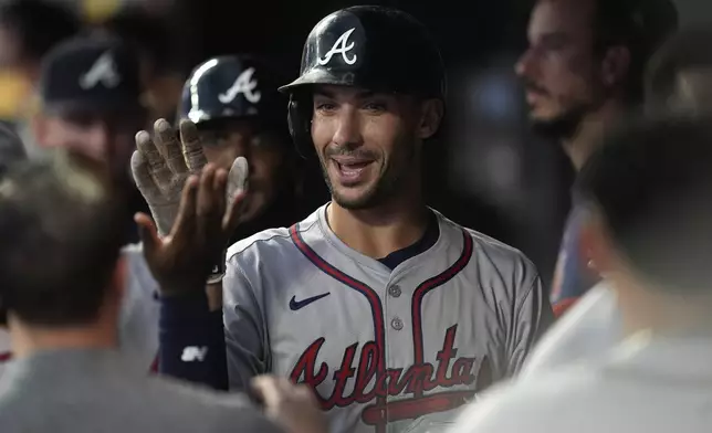 Atlanta Braves' Matt Olson, center, celebrates in the dugout after hitting a three-run home run during the first inning of a baseball game against the Minnesota Twins, Monday, Aug. 26, 2024, in Minneapolis. (AP Photo/Abbie Parr)