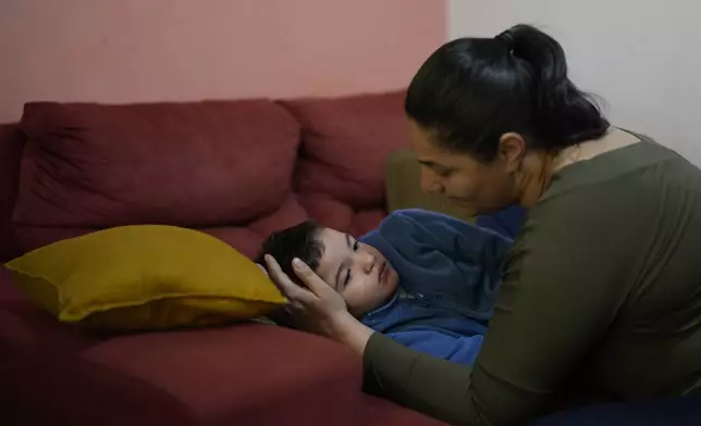 Janaina Silva watches over her four-year-old son Murillo after an epileptic seizure at her parents' home in Guaruja, Brazil, Monday, July 8, 2024. To lessen and shorten his seizures, Murillo takes a steady dose of liquid cannabidiol or CBD, that Silva acquires for free through Sao Paulo state’s public health system. (AP Photo/Andre Penner)