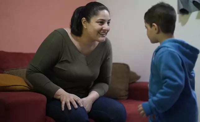 Janaina Silva smiles at her four-year-old son Murillo, who has severe epilepsy, at her parents' home in Guaruja, Brazil, Monday, July 8, 2024. To lessen and shorten his seizures, Murillo takes a steady dose of liquid cannabidiol or CBD, that Silva acquires for free through Sao Paulo state’s public health system. (AP Photo/Andre Penner)