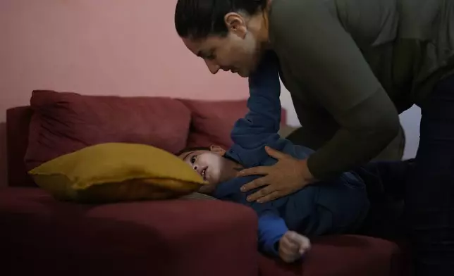 Janaina Silva tends to her four-year-old son Murillo during an epileptic seizure, at her parents' home in Guaruja, Brazil, Monday, July 8, 2024. To lessen and shorten his seizures, Murillo takes a steady dose of liquid cannabidiol or CBD, that Silva acquires for free through Sao Paulo state’s public health system. (AP Photo/Andre Penner)