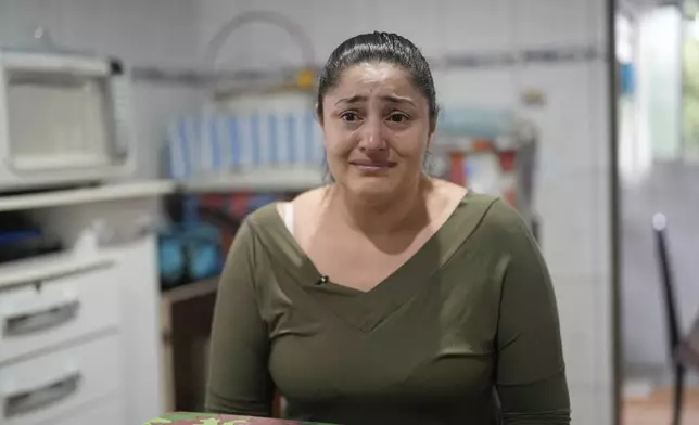 Janaina Silva cries during an interview while talking about her four-year-old son Murillo, who suffers from severe epilepsy, at her parents' home in Guaruja, Brazil, Monday, July 8, 2024. To lessen and shorten his seizures, Murillo takes a steady dose of liquid cannabidiol (CBD) that Silva acquires for free through Sao Paulo state’s public health system. (AP Photo/Andre Penner)