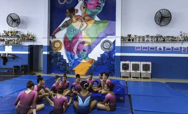 Gymnasts chat before a training session at Bonifacio Cardoso gymnasium, where Olympic medalist Rebeca Andrade trained as a child in her hometown of Guarulhos, Sao Paulo, Brazil, Tuesday, Aug. 6, 2024. (AP Photo/Tuane Fernandes)