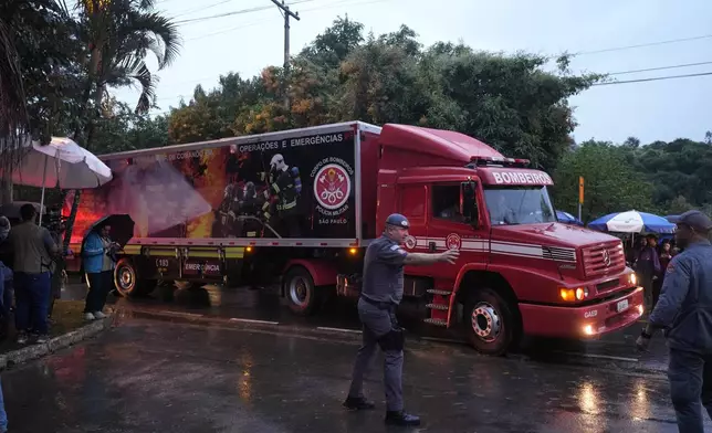 A refrigerated truck from the fire department arrives at the gated community where a plane crashed in Vinhedo, Sao Paulo state, Brazil, Friday, Aug. 9, 2024. (AP Photo/Andre Penner)