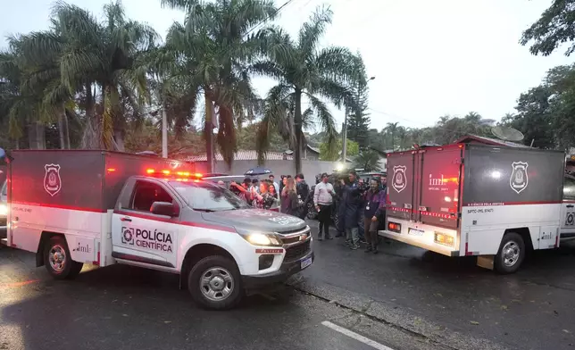 Police vehicles used to carry bodies arrive at the gated community where a plane crashed in Vinhedo, Sao Paulo state, Brazil, Friday, Aug. 9, 2024. (AP Photo/Andre Penner)