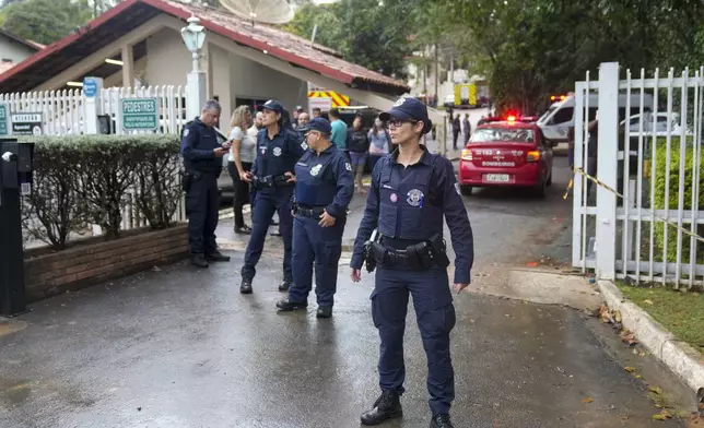 Police guard the gated community where a plane crashed in Vinhedo, Sao Paulo state, Brazil, Friday, Aug. 9, 2024. (AP Photo/Andre Penner)