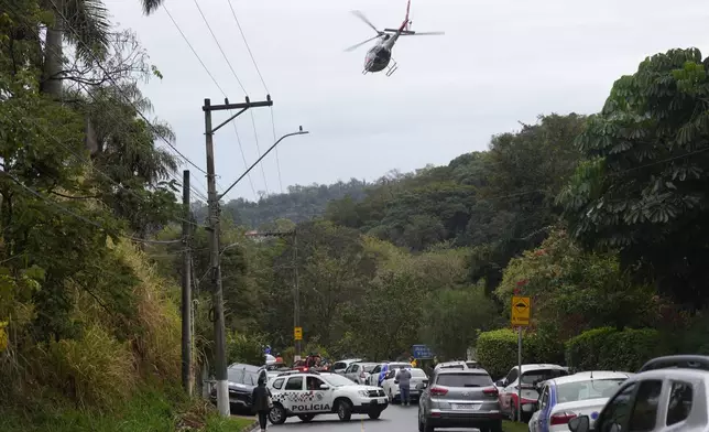 Police patrol the street leading to the gated community where a plane crashed in Vinhedo, Sao Paulo state, Brazil, Friday, Aug. 9, 2024. (AP Photo/Andre Penner)