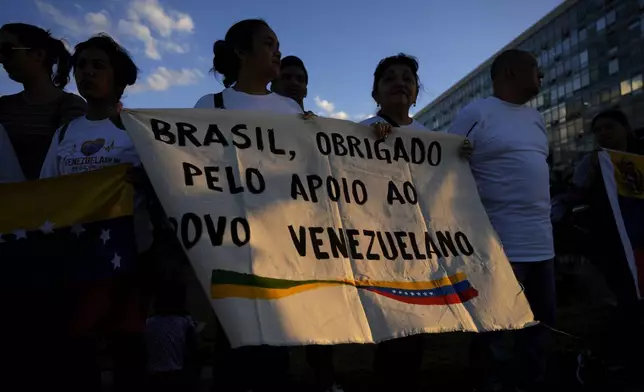 Venezuelan nationals hold a sign with a message that reads in Portuguese: "Brazil, thank you for your support of the Venezuelan people", during a demonstration in support of opposition Venezuelan presidential candidate Edmundo Gonzalez, in front of the Itamaraty Palace, in Brasilia, Brazil, Thursday, Aug. 1, 2024. (AP Photo/Eraldo Peres)