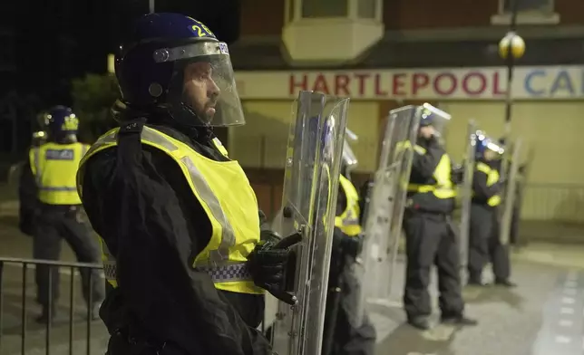 Police officers stand guard on the streets of Hartlepool, England, following a violent protest in the wake of the killing of three girls who were fatally stabbed in northwest England, Wednesday, July 31, 2024. Far-right groups seek to stir anger over an attack they have sought to link — without evidence — to immigrants. (Owen Humphreys/PA via AP)