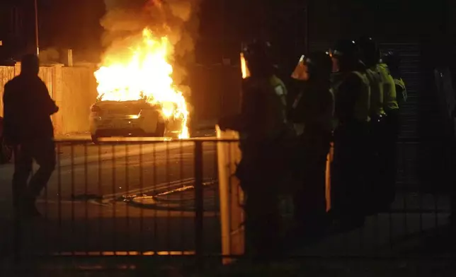 A police car burns as officers are deployed on the streets of Hartlepool, England, following a violent protest in the wake of the killing of three girls who were fatally stabbed in northwest England, Wednesday, July 31, 2024. Far-right groups seek to stir anger over an attack they have sought to link — without evidence — to immigrants. (Owen Humphreys/PA via AP)