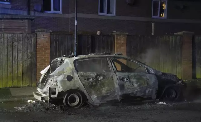 A burnt out police vehicle as police officers are deployed on the streets of Hartlepool, England, following a violent protest in the wake of the killing of three girls who were fatally stabbed in northwest England, Wednesday, July 31, 2024. Far-right groups seek to stir anger over an attack they have sought to link — without evidence — to immigrants. (Owen Humphreys/PA via AP)