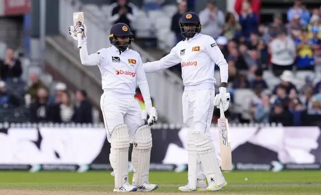 Sri Lanka's Kamindu Mendis, left, celebrates his half-century with Milan Rathnayake on day three of the First Test match between England and Sri Lanka at Emirates Old Trafford, Manchester, England, Friday Aug. 23, 2024. (Nick Potts/PA via AP)