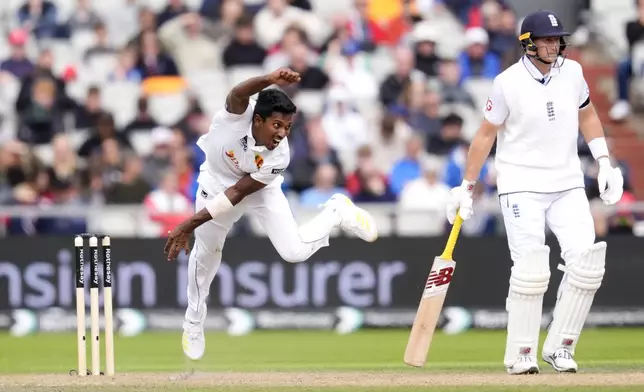 Sri Lanka's Vishwa Fernando, left, bowls on day two of the First Test match between England and Sri Lanka at Emirates Old Trafford, Manchester, England, Thursday Aug. 22, 2024. (Nick Potts/PA via AP)