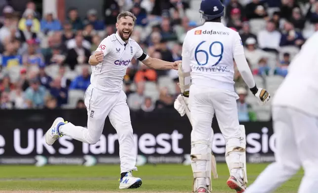 England's Chris Woakes, left, celebrates taking the wicket of Sri Lanka's Angelo Mathews on day three of the First Test match between England and Sri Lanka at Emirates Old Trafford, Manchester, England, Friday Aug. 23, 2024. (Nick Potts/PA via AP)