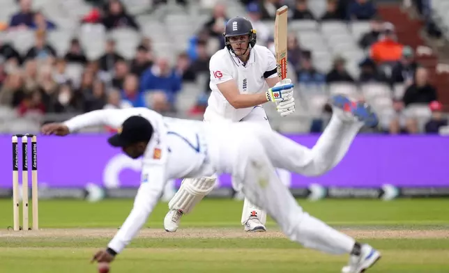 England's Jamie Smith hits the ball past Sri Lanka's Kamindu Mendis for a boundary during day two of the First Test match between England and Sri Lanka at Emirates Old Trafford, Manchester, England, Thursday Aug. 22, 2024. (Nick Potts/PA via AP)