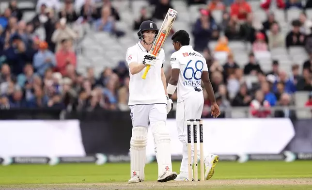 England's Harry Brook celebrates reaching a half century on day two of the First Test match between England and Sri Lanka at Emirates Old Trafford, Manchester, England, Thursday Aug. 22, 2024. (Nick Potts/PA via AP)