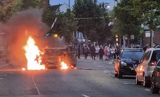 A vehicle is set alight in Belfast, Northern Ireland, following an anti-Islamic protest outside Belfast City Hall on Saturday, Aug. 3, 2024. (David Young/PA via AP)