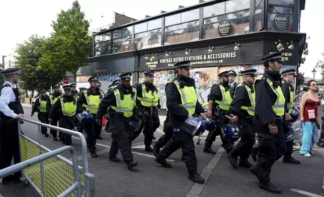 Police officers on Ladbroke Grove as the Notting Hill Carnival takes place, in west London, Monday, Aug. 26, 2024. (Lucy North/PA via AP)