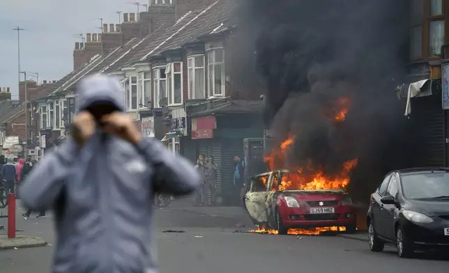 A car burns during an anti-immigration protest in Middlesbrough, England, Sunday Aug. 4, 2024. (Owen Humphreys/PA via AP)