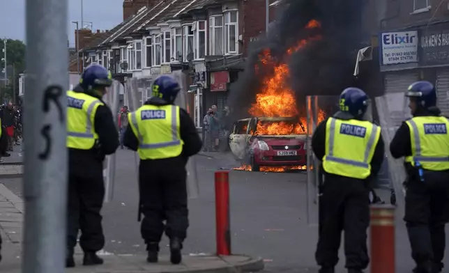 A car burns during an anti-immigration protest in Middlesbrough, England, Sunday Aug. 4, 2024. (Owen Humphreys/PA via AP)