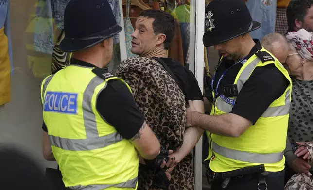 A man is detained by police officers during a protest in Nottingham Market Square, England, Saturday Aug. 3, 2024, following the stabbing attacks on Monday in Southport, in which three young children were killed. (Jacob King/PA via AP)