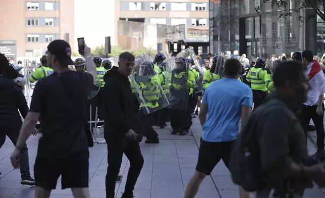 Police face protesters in Liverpool, England, Saturday Aug. 3, 2024, following the stabbing attacks on Monday in Southport, in which three young children were killed. (James Speakman/PA via AP)