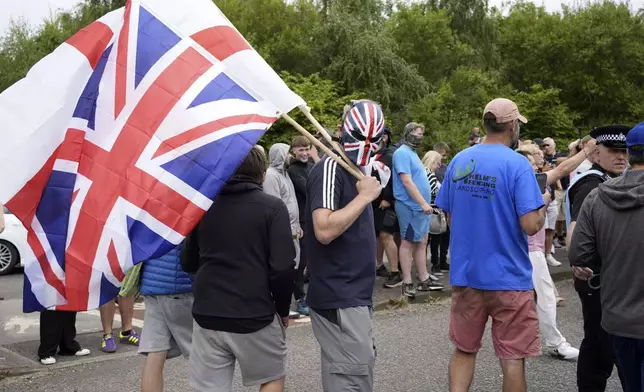 Protesters gather outside the Holiday Inn Express in Rotherham, England, Sunday, Aug. 4, 2024. The violence erupted earlier this week in cities and towns across Britain, ostensibly in protest of Monday's mass stabbing in Southport. A 17-year-old male has been arrested and charged with murder and attempted murder in connection with the Southport attack. False rumors spread online that the young man was a Muslim and an immigrant, fueling anger among far-right supporters. (Danny Lawson/PA via AP)