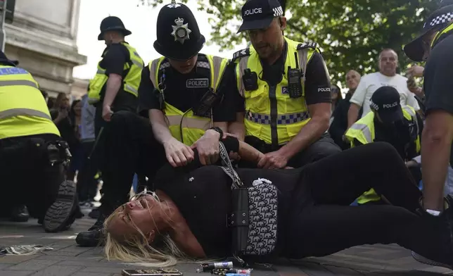 A woman is detained by police officers during a protest in Nottingham, England's Market Square Saturday Aug. 3, 2024, following the stabbing attacks on Monday in Southport, in which three young children were killed. (Jacob King/PA via AP)