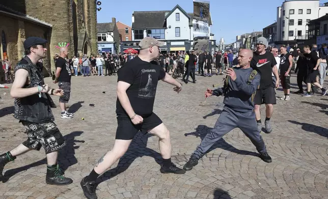 A fight breaks out between anti-fascists, left, and other people protesting in Blackpool, England, Saturday Aug. 3, 2024, following the stabbing attacks on Monday in Southport, in which three young children were killed. (Michael Holmes/PA via AP)