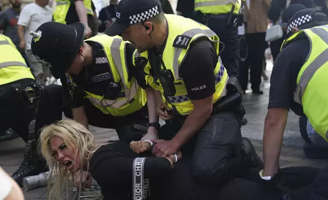 Police officers detain a woman during a protest in Nottingham, England's Market Square Saturday Aug. 3, 2024, following the stabbing attacks on Monday in Southport, in which three young children were killed. (Jacob King/PA via AP)