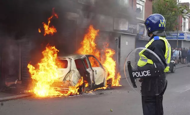 A car burns on Parliament Road during an anti-immigration protest in Middlesbrough, England, Sunday Aug. 4, 2024. (Owen Humphreys/PA via AP)