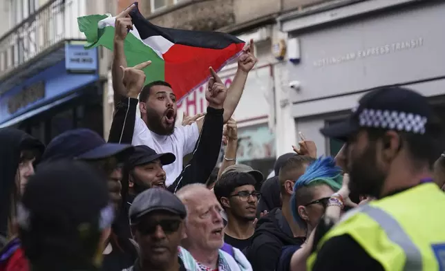 EDS NOTE: OBSCENITY - People counter demonstrate in Nottingham Market Square against people protesting at the same location following the stabbing attacks on Monday in Southport, in which three young children were killed, in Nottingham, England, Saturday August 3, 2024. (Jacob King/PA via AP)