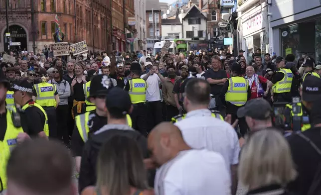 People counter demonstrate in Nottingham, England's Market Square on Saturday, Aug. 3, 2024, following Monday's stabbing attacks in Southport, in which three young children were killed. (Jacob King/PA via AP)