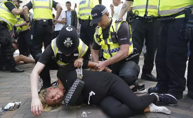 Police officers detain a woman during a protest in Nottingham, England's Market Square Saturday Aug. 3, 2024, following the stabbing attacks on Monday in Southport, in which three young children were killed. (Jacob King/PA via AP)