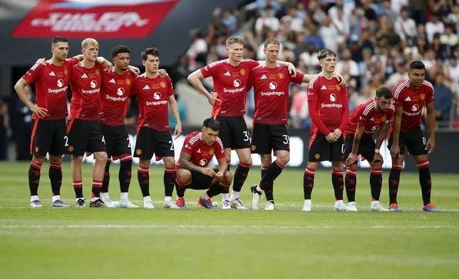 Manchester United players stand together during the penaty shootout during the FA Community Shield soccer match between Manchester City and Manchester United at Wembley Stadium in London, Saturday, Aug. 10, 2024. (AP Photo/David Cliff)