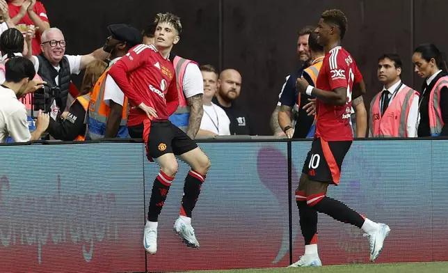 Manchester United forward Alejandro Garnacho, left, and Manchester United forward Marcus Rashford celebrate after scoring their side's first goal during the FA Community Shield soccer match between Manchester City and Manchester United at Wembley Stadium in London, Saturday, Aug. 10, 2024. (AP Photo/David Cliff)