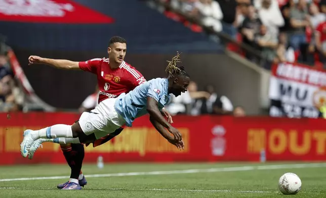 Manchester United defender Diogo Dalot , left, and Manchester City forward Jérémy Doku challenge for the ball during the FA Community Shield final soccer match between Manchester City and Manchester United at Wembley Stadium in London, Saturday, Aug. 10, 2024. (AP Photo/David Cliff)