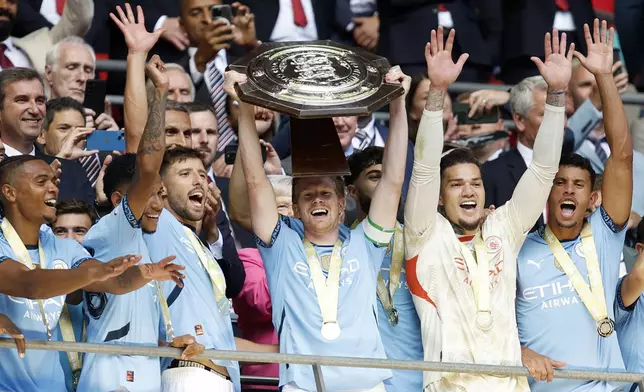 Manchester City midfielder Kevin De Bruyne lifts the trophy after his team won the FA Community Shield soccer match between Manchester City and Manchester United at Wembley Stadium in London, Saturday, Aug. 10, 2024. (AP Photo/David Cliff)