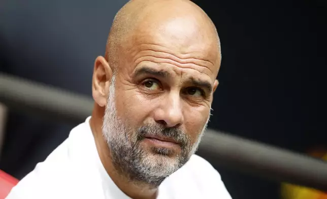 Manchester City's head coach Pep Guardiola watches his team during the FA Community Shield final soccer match between Manchester City and Manchester United at Wembley Stadium in London, Saturday, Aug. 10, 2024. (AP Photo/David Cliff)