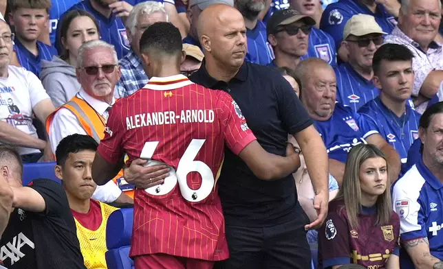 Liverpool's manager Arne Slot hugs Liverpool's Trent Alexander-Arnold as he is substituted during the English Premier League soccer match between Ipswich Town and Liverpool at Portman Road stadium in Ipswich, England, Saturday, Aug. 17, 2024. (AP Photo/Alastair Grant)