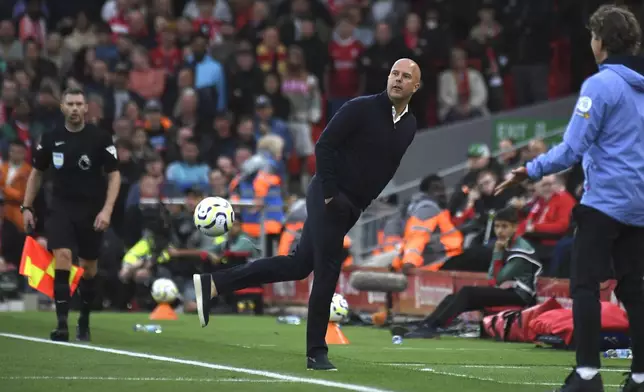 Liverpool's manager Arne Slot kicks the ball during the English Premier League soccer match between Liverpool and Brentford at Anfield Stadium, Liverpool, England, Sunday, Aug. 25, 2024. (AP Photo/Rui Vieira)