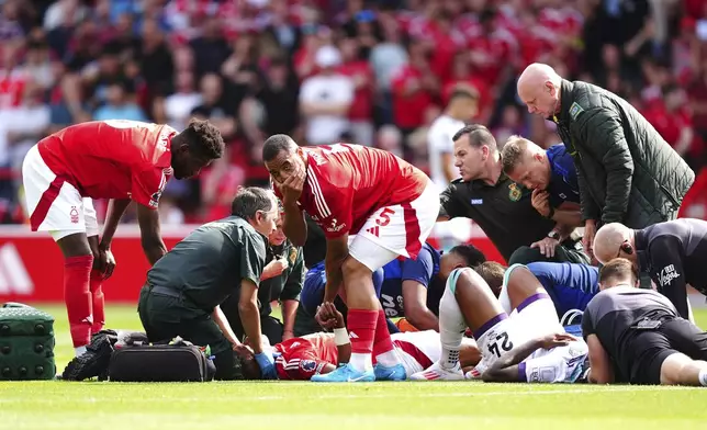 Nottingham Forest's Danilo, centre, receives treatment for an injury as team-mate Murillo reacts during the British Premier League soccer match between Nottingham Forest and AFC Bournemouth, at the City Ground, Nottingham, England, Saturday Aug. 17, 2024. (Mike Egerton/PA via AP)