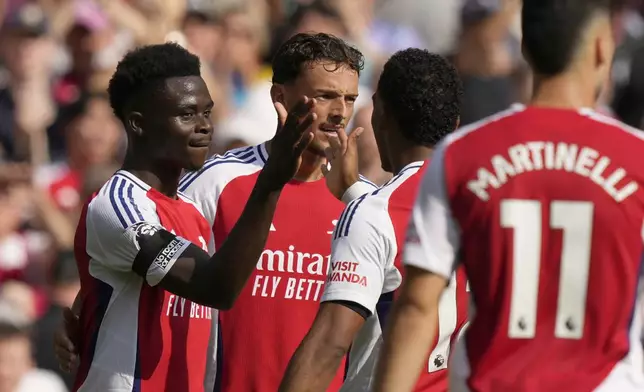 Arsenal's Bukayo Saka, left, celebrates after scoring his side's second goal during the English Premier League soccer match between Arsenal and Wolverhampton Wanderers at Emirates Stadium in London, England, Saturday, Aug. 17, 2024. (AP Photo/Frank Augstein)