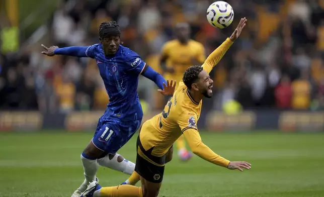 Chelsea's Noni Madueke, left, and Wolverhampton Wanderers' Matheus Cunha battle for the ball during the English Premier League soccer match between Wolverhampton Wanderers and Chelsea at Molineux Stadium, Wolverhampton, England. Sunday Aug. 25, 2024. (Joe Giddens/PA via AP)