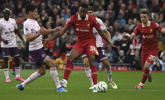 Liverpool's Ryan Gravenberch, centre, challenges for the ball with Brentford's Christian Norgaard during the English Premier League soccer match between Liverpool and Brentford at Anfield Stadium, Liverpool, England, Sunday, Aug. 25, 2024. (AP Photo/Rui Vieira)